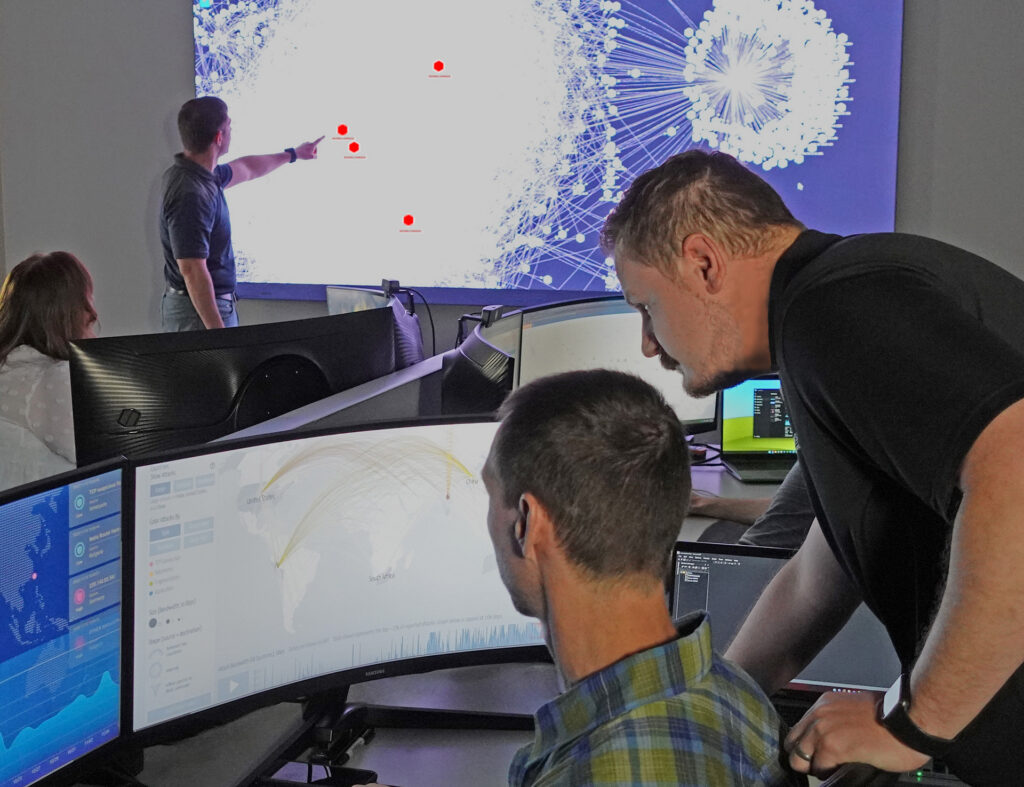 People looking at a screen in a cybersecurity room