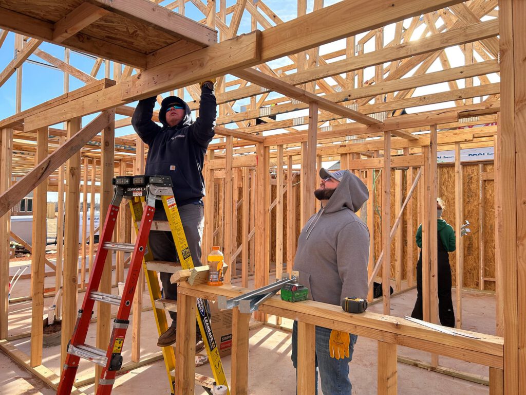 Two men framing a house